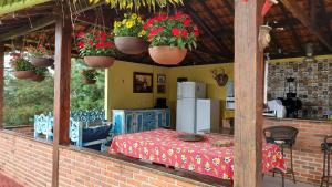 a kitchen with a table and flowers in a room at Santa Anna Ecohouse in Penedo