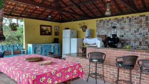 a kitchen with a table and a kitchen with a refrigerator at Santa Anna Ecohouse in Penedo