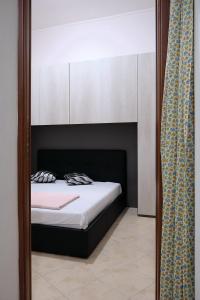 espejo reflejo de una cama en un dormitorio en Casetta di Diego en Tivoli