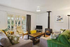 a living room with a couch and a wood stove at Pendreigh Cottage - Martinborough Holiday Home in Martinborough 