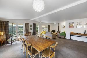 a living room with a wooden table and chairs at Pendreigh Cottage - Martinborough Holiday Home in Martinborough 