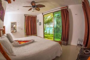 a bedroom with a bed and a large window at San Fernando, Bacalar Villa Nina Del Río in Bacalar