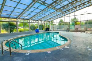 a large swimming pool with a glass ceiling at Best Western Plus Lafayette Hotel University Area in Lafayette