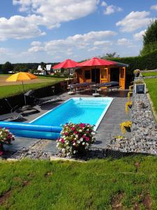 a swimming pool with umbrellas and a house at Haus Sonnenschein in Holzbach