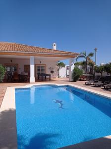 - une piscine en face d'une maison dans l'établissement Villa Grande - Cala Golf, à Mijas