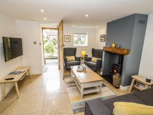 a living room with a couch and a fireplace at Middle Cottage in Southam