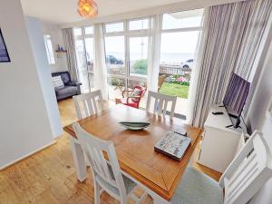 a dining room with a table and chairs and a window at Stonesthrow - Bognor Regis in Bognor Regis