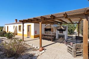 a patio with a wooden pergola and a bench at Monte do Tanoeiro - Casa Adega in Rogil