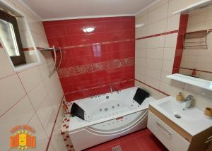 a red bathroom with a tub and a sink at POARTA SOARELUI in Teliucu Inferior +14 photos