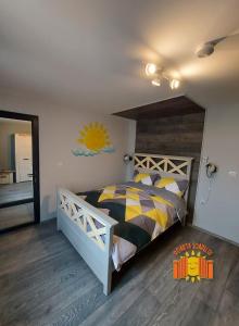 a bedroom with a large bed with a wooden headboard at POARTA SOARELUI in Teliucu Inferior