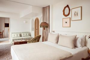- une chambre blanche avec un lit et une chaise dans l'établissement Hôtel Monsieur Aristide, à Paris
