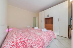 a bedroom with a pink and white bed and cabinets at Casa Vista Cipressi in Varenna