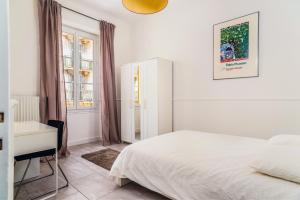 1 dormitorio con cama, escritorio y ventana en Modern 2-bedroom City Center Apartment, en Niza
