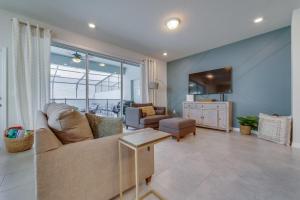 a living room with a couch and a tv at Windsor Island Resort 5 Bedroom Townhome Private Pool Disney in Davenport