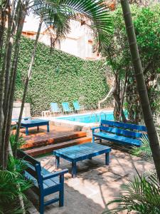 a group of blue benches next to a swimming pool at Pousada Bicho do Mar in Arraial do Cabo