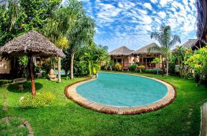 a swimming pool in the yard of a house at Le Zahir Lodge in Ambatoloaka