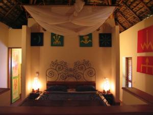 a bedroom with a bed with a canopy and two lamps at Le Zahir Lodge in Ambatoloaka