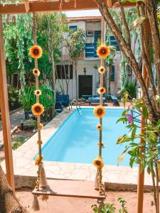 a pool with sunflowers on poles next to a house at Pousada Bicho do Mar in Arraial do Cabo