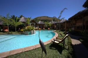 a statue of a boat next to a swimming pool at Le Zahir Lodge in Ambatoloaka +20 photos