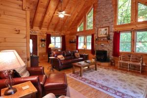 una sala de estar con muebles de cuero en una cabaña de madera en The Crows Nest en Lake Lure