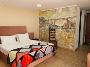 1 dormitorio con 1 cama y una pintura en la pared en Gojim Casa Rural, en Armamar