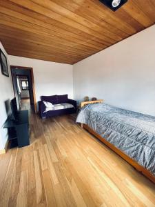 - une chambre avec un lit et un plafond en bois dans l'établissement Casa Andina, à San Carlos de Bariloche