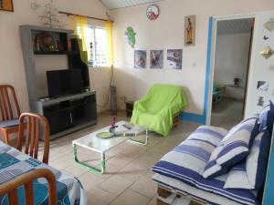 uma sala de estar com um sofá e uma mesa em Villa Fleurs Amande em Marigot