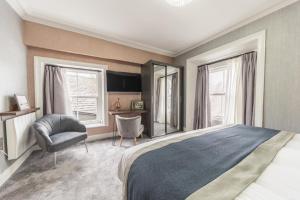 a bedroom with a bed and a chair and a desk at The Old Stamp House Retreat - Three En-suite Bedrooms with Parking in Ambleside