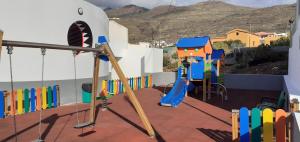 einen Spielplatz mit Schaukel und Rutsche in der Unterkunft Apartamento La Caleta Isla de El Hierro terrace with incredible views in La Caleta