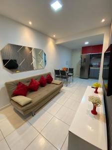 ein Wohnzimmer mit Sofa und Tisch in der Unterkunft Muro Alto Condomínio Clube - Apto 314 in Porto De Galinhas