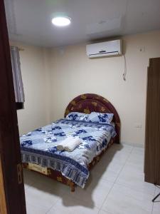 a bedroom with a bed with a blue comforter at Ciudad del Este - Departamento con 2 habitaciones, Paraguay in Ciudad del Este