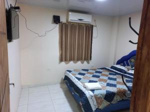 1 dormitorio con 1 cama con manta y ventana en Ciudad del Este - Departamento con 2 habitaciones, Paraguay, en Ciudad del Este