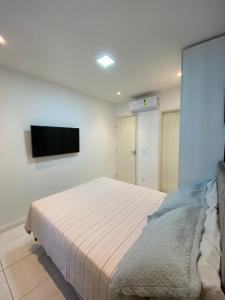 ein Schlafzimmer mit einem Bett und einem Flachbildfernseher in der Unterkunft Muro Alto Condomínio Clube - Apto 314 in Porto De Galinhas + 32 Fotos
