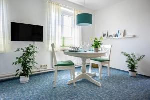 a dining room with a table and two chairs and a tv at Knusthof - Wohnung 1 in Albertsdorf