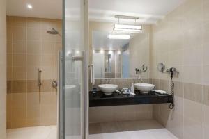 y baño con 2 lavabos y ducha. en Radisson Blu Anchorage Hotel en Lagos