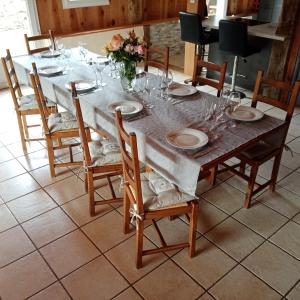 - une table avec des assiettes et des verres à vin dans l'établissement Le gîte Le Marillet, à Thorigny