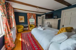 a bedroom with two beds and a red rug at Sally Webster Inn in Rockport