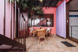a dining room with a table and chairs and pink walls at Divi Apartments Villa Reyes 2 in Seville