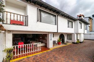 a white house with a red bench on a brick driveway at Ayenda Puerto Madero Boutique in Chía +31 photos