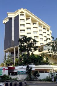 a large white building with a tree in front of it at Gokulam Park in Cochin