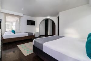 Habitación de hotel con 2 camas y TV en Ayenda Puerto Madero Boutique, en Chía