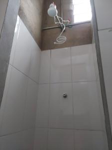 a shower stall with white tiles and a light at Pousada Vila da Serra - Quarto do Amor in Nova Lima