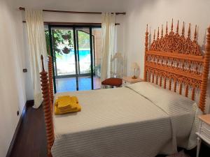 a bedroom with a large bed with a wooden headboard at Penalva Beach House in Troia