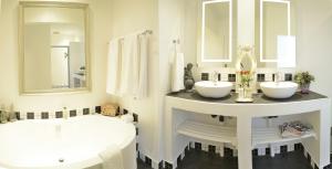 a white bathroom with two sinks and a mirror at Duke & Duchess Boutique Hotel in Pretoria
