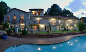 a house with a pool in front of it at Duke & Duchess Boutique Hotel in Pretoria