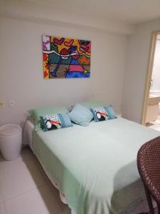 een slaapkamer met een bed met een schilderij aan de muur bij Flat Nord Tabatinga in Conde