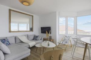 ein Wohnzimmer mit einem Sofa und einem Tisch in der Unterkunft L'appartement Océane - Welkeys in Capbreton