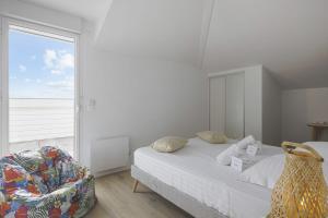 ein Schlafzimmer mit einem Bett, einem Stuhl und einem Fenster in der Unterkunft L'appartement Océane - Welkeys in Capbreton