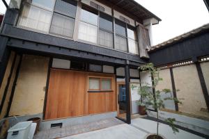 a house with a wooden door in front of it at WATOWA in Yunotu