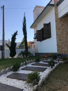 einen Garten mit Felsen und ein Gebäude mit Fenster in der Unterkunft Casa Aconchego dos Canyons in Praia Grande